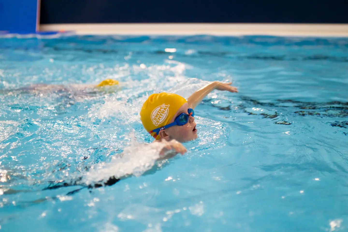 Toddler learning how to swim in a butterfly stroke