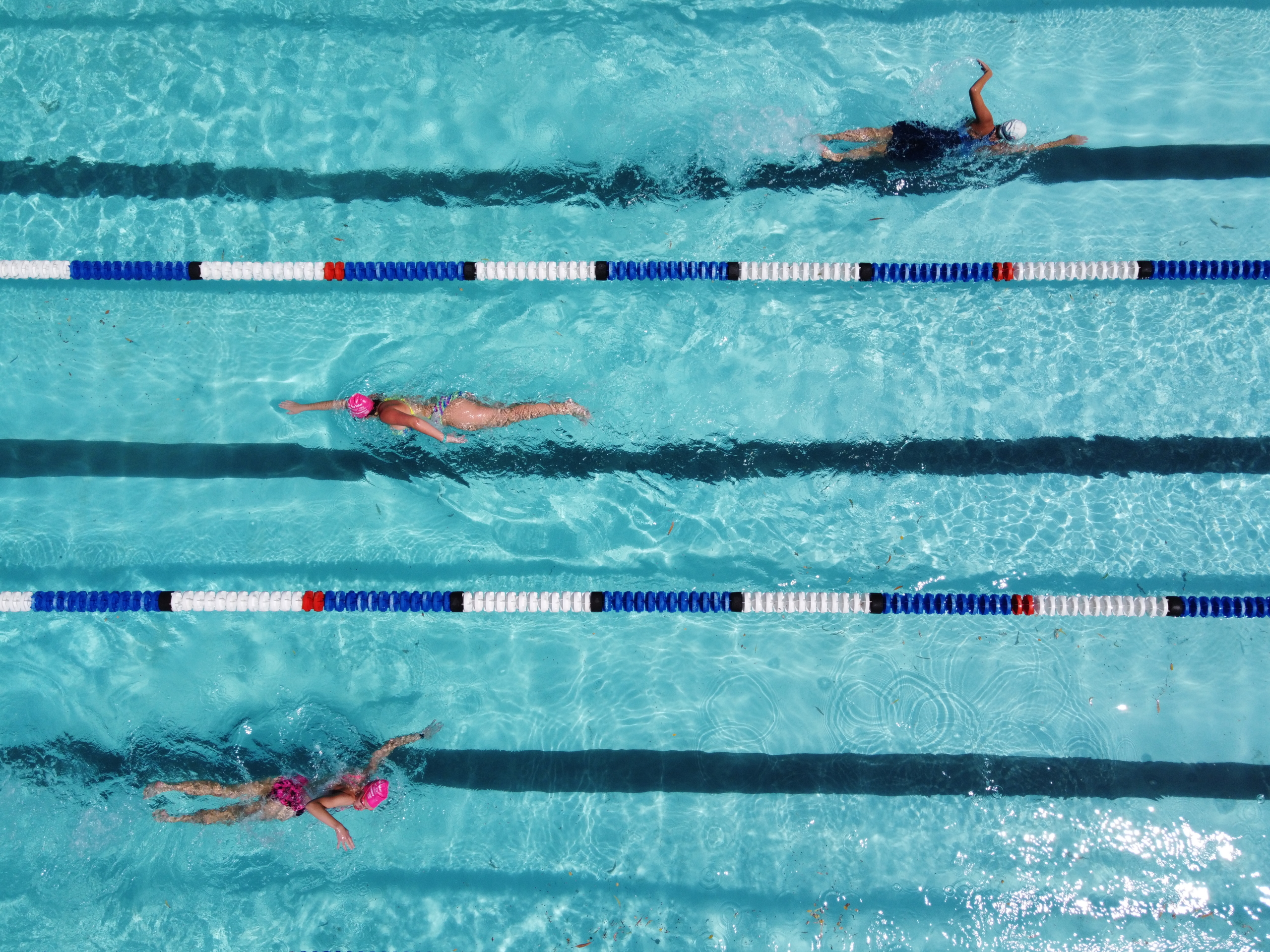 People lane swimming at different speeds