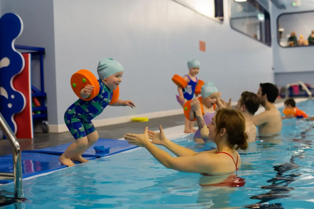 Parents catching their babies and toddlers as they jump into the pool excitedly