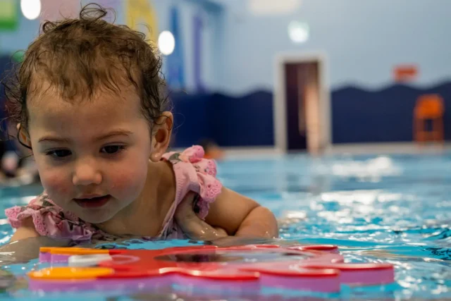 A cute baby playing in the pool