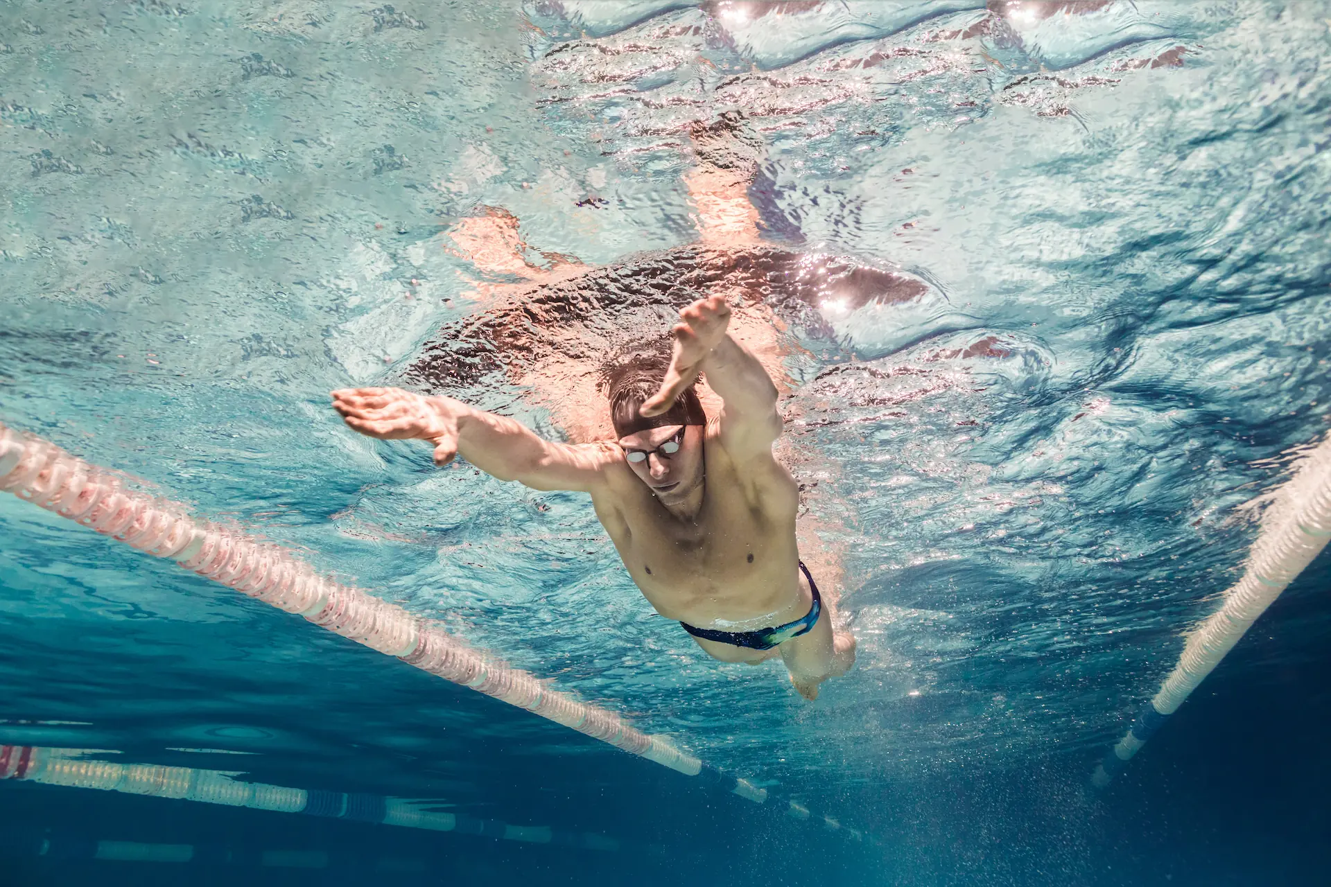 Swimmer in streamlined position perfecting his technique