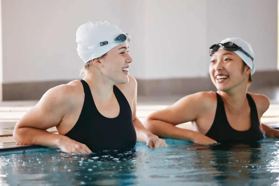Two women talking in a pool during swimming lesson